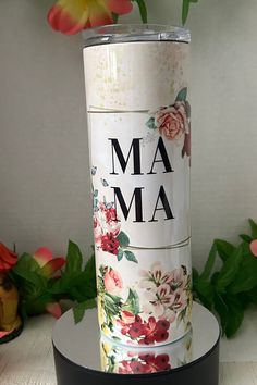 a flower vase with the word ma on it sitting on top of a black stand