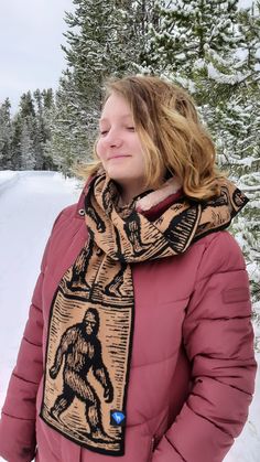 a woman standing in the snow with her eyes closed and wearing a scarf around her neck