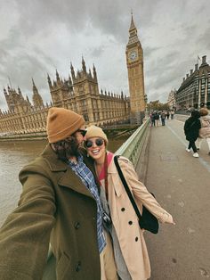 two people taking a selfie in front of the big ben clock tower