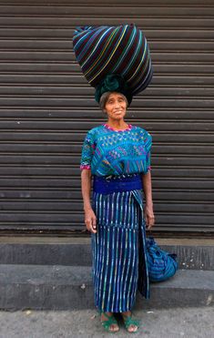 a woman standing in front of a garage door with a large hat on her head