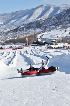 two people riding in a snow covered sled