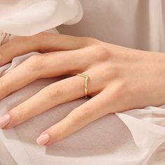 a woman's hand with a gold ring on it