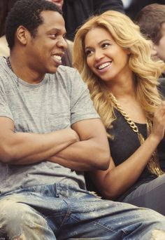 a man and woman sitting next to each other in front of a group of people