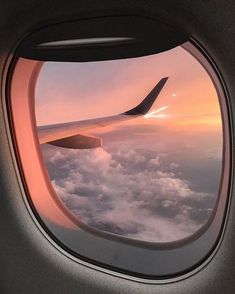 an airplane window looking out at the clouds