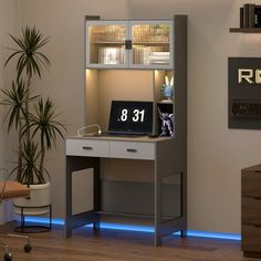 a computer desk with a clock on it in a home office area next to a potted plant