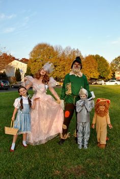 three people dressed up in costumes posing for a photo with two children and one adult