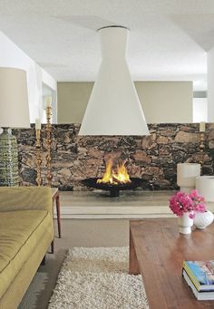 a living room filled with furniture and a fire place next to a wall mounted fireplace