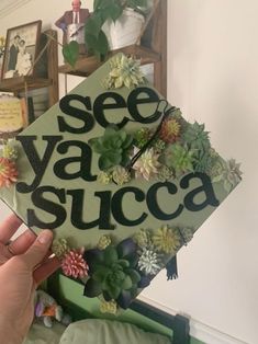 someone holding up a graduation cap with succulents on it that says see ya succa