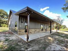 a large metal building sitting on top of a grass covered field