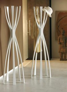 two white vases sitting next to each other on top of a table in a room