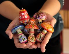 a person holding several colorfully decorated objects in their hands, with one hand on the other