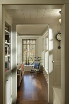 an open door leading to a living room with a chair and bookshelf in it