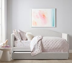 a white daybed with pillows and blankets on it