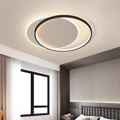 a bed room with a neatly made bed and a round light