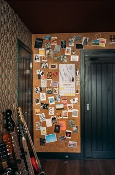 a cork board wall with pictures and guitar heads on it in a room that is decorated with guitars