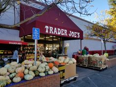 there are many pumpkins and gourds on display outside the trader joe's