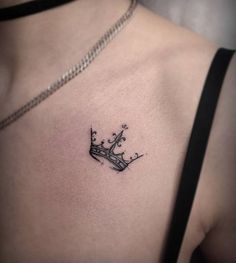 a woman's chest with a crown tattoo on it