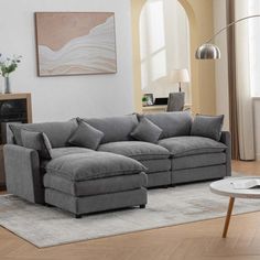 a living room filled with furniture and a white rug on top of a hard wood floor