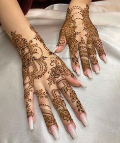 a woman's hands with hennap on it and her hand painted in intricate designs