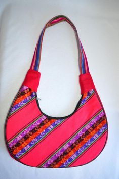 Beautiful pink and multicolored tones purse made in Latin America.DIMENSIONS:6" inches (15.247 centimeters) height12" inches (30.48 centimeters) Length2.5" inches (6.35 centimeters) Wide22" inches (55.88 centimeters) Shoulder strap lengthPRODUCT SPECIFICATIONS:-Brand: None-Country of origin:  Latin America-Style: Purse / Handbag / Shoulder bag-Construction:  Front and back same handwoven fabric design.-Hardware: Silvered zipper-Lining: black polyester fabric-Inside pockets: 1 wall pocket with no Bag Construction, Mexican Purse, Purse Essentials, Burlap Bags, Fabric Handbags, Bag Fabric, Hobo Shoulder Bag, Handwoven Fabric, Silver Zipper