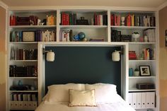 a bed sitting in front of a book shelf filled with books