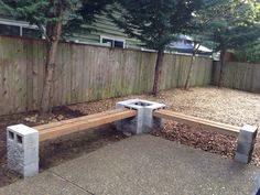 a concrete bench sitting next to a wooden fence