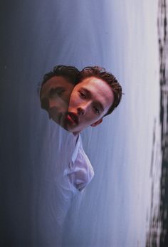 a man in white shirt and tie standing next to water