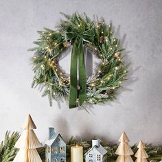 a wreath on the wall with christmas decorations around it