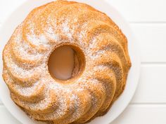 a bundt cake sitting on top of a white plate covered in powdered sugar