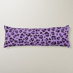 a purple and black leopard print pillow on a white wall