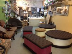 a room filled with lots of different types of chairs and foot stools in it