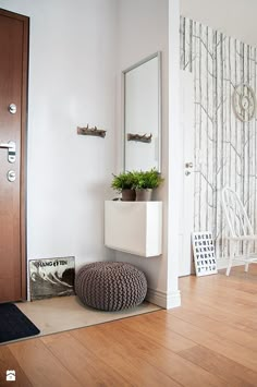 a room with a chair, mirror and potted plant on the floor in front of it