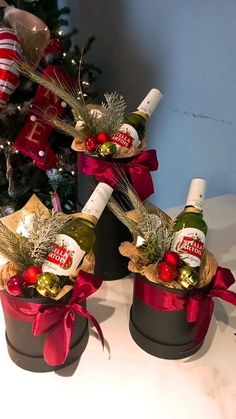 three wine bottles in buckets with christmas decorations