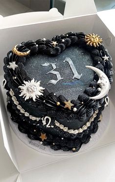 a heart shaped cake with stars and moon decorations on it's side in a box