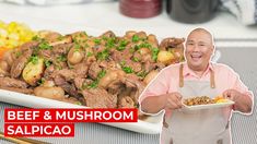 a man holding a plate of food next to a platter of meat and mushrooms