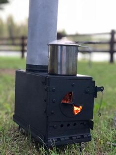 an old fashioned stove is sitting in the grass