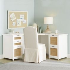 a white chair sitting in front of a desk with a lamp on top of it