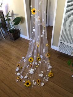 a sheer curtain with sunflowers and daisies attached to it in front of a door