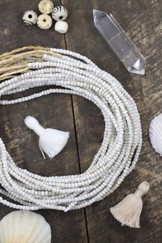 some white beads and shells on a wooden table