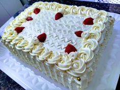 a cake with white frosting and strawberries sitting on top of a countertop