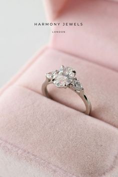 a diamond ring sitting on top of a pink velvet box with the words harmony jewels