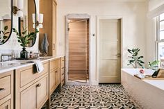 a bathroom with a bathtub, sink and large mirror on the wall above it