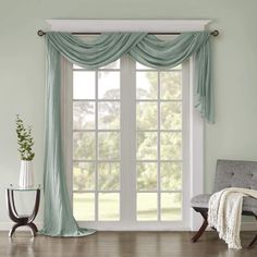 a living room filled with furniture and a window covered in blue drapes next to a chair