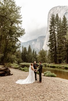 a bride and groom standing in front of a mountain