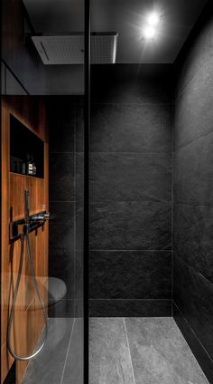 a black and white photo of a shower in a bathroom with wood paneling on the walls