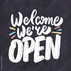 welcome we're open handwritten lettering on chalkboard with crayon pencils