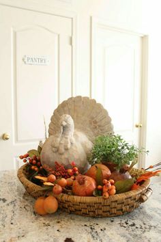 a turkey sitting on top of a basket filled with fruit