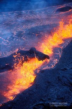 lava flowing into the ocean with bright orange flames coming out of it's sides