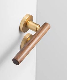 an image of a wooden handle on a white door with gold trim and knobs