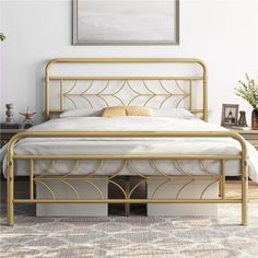 a white bed with gold metal frame and headboard in a bedroom setting that is well decorated